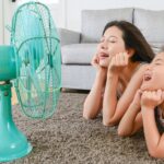two ladies in front of a fan in a warm home