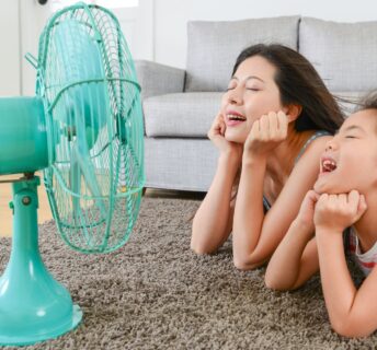two ladies in front of a fan in a warm home