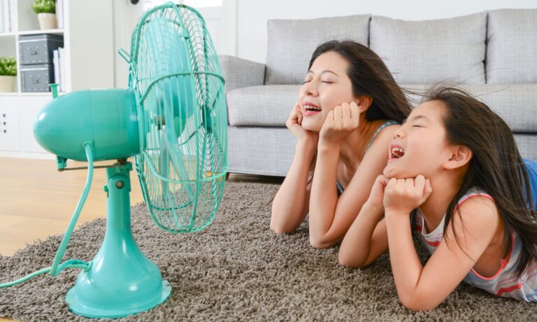 two ladies in front of a fan in a warm home