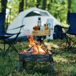 Photo of camp site with two folding chairs and fire