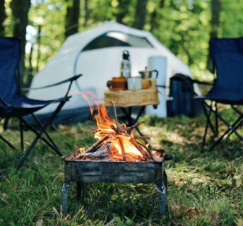 Photo of camp site with two folding chairs and fire