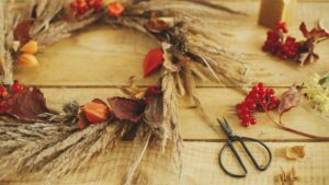 Blog - DIY Fall Decor Image. Pinecone, leaves, scissors, etc on a table.